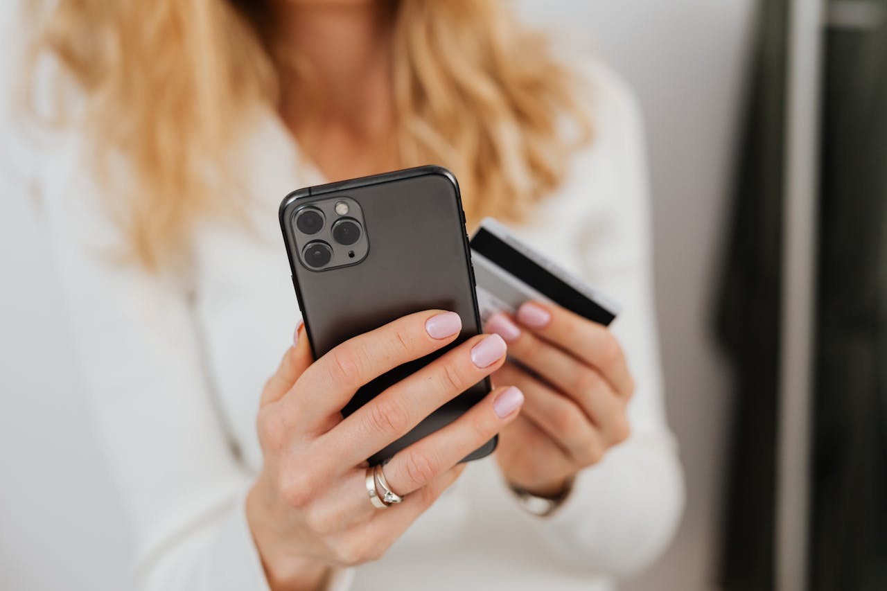 una mujer con una tarjeta de crédito y un celular